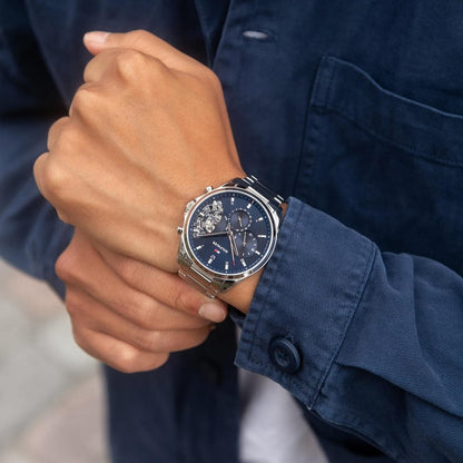 Casual lifestyle shot of the Tommy Hilfiger 1710448 Baker silver watch paired with a blue button-down shirt.
