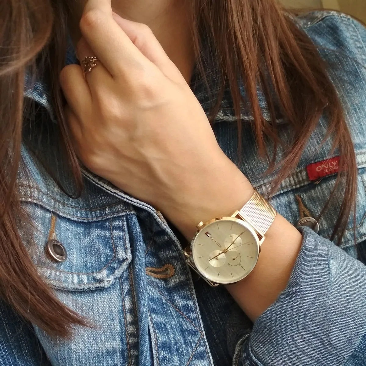 Angled view of Tommy Hilfiger 1781943 women's gold mesh strap watch worn on wrist, emphasizing its sleek design