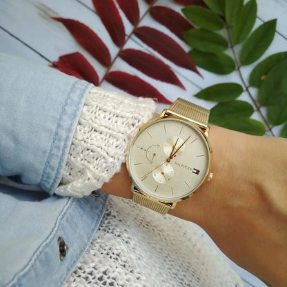Close-up shot of Tommy Hilfiger 1781943 women’s gold mesh watch worn on wrist with gold dial