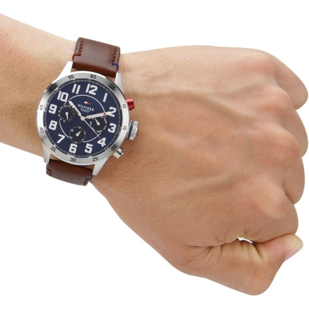 Tommy Hilfiger 1791066 men’s watch worn on wrist with brown leather strap and blue dial.