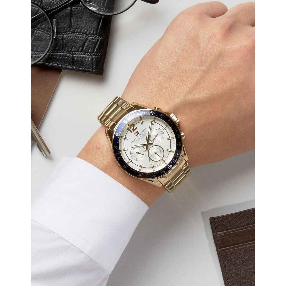 Tommy Hilfiger 1791121 men's gold watch with white dial shown on wrist