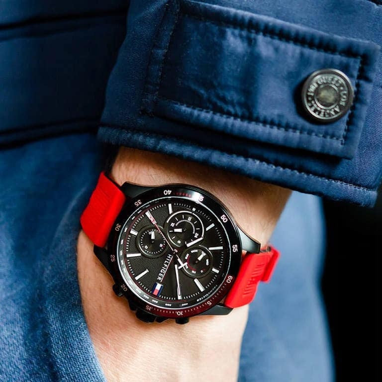 Tommy Hilfiger 1791722 men’s watch with red silicone strap, black dial worn on wrist